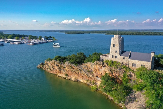 Aerial view of Tucker Tower on Lake Murray in Ardmore Oklahoma on a summer day with a houseboat in the distance