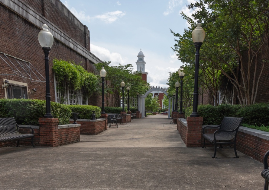 Opelika, Alabama/USA-May 10, 2019: Quaint brick courtyard in downtown Opelika with the Lee County Courthouse visible in the distance.