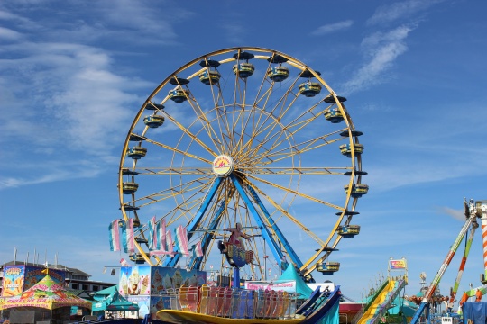 Sedalia, Missouri / USA - August 12 2019: Ferris Wheel at Missouri State Fair beneath Mostly Clear Sky in Summer Time