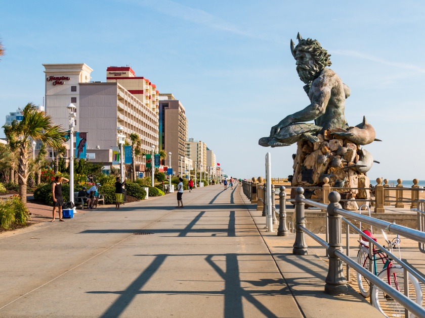 VIRGINIA BEACH, VIRGINIA - JULY 13, 2017: The King Neptune statue by sculptor Paul DiPasquale along the 3-mile long oceanfront boardwalk lined with high-rise hotels.