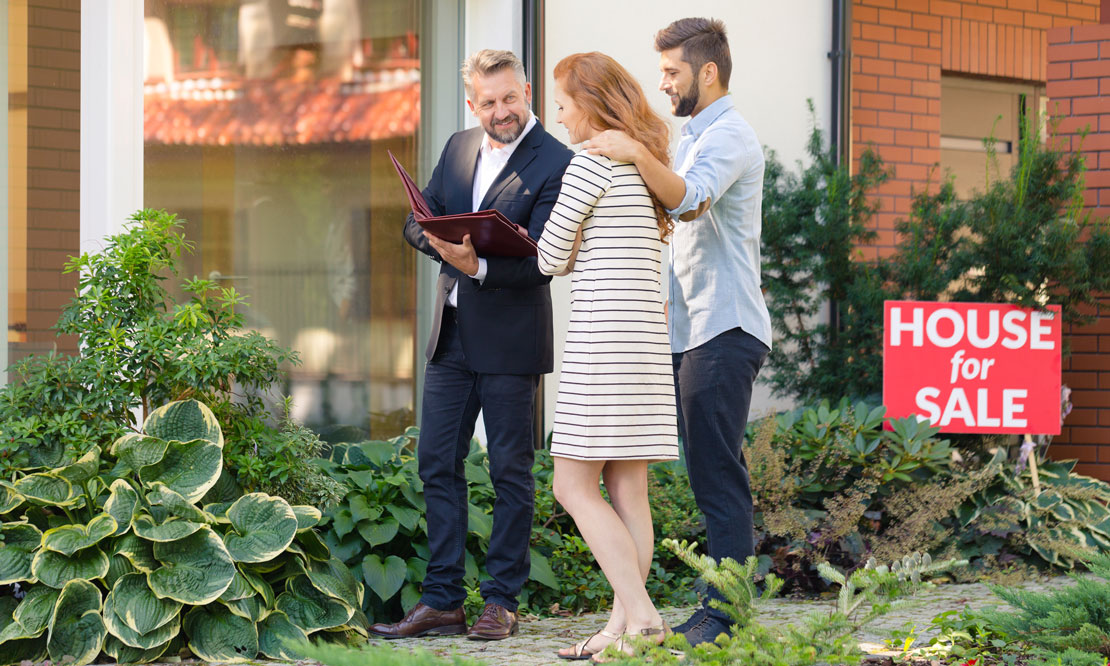 Owners walking around their home with real estate agent