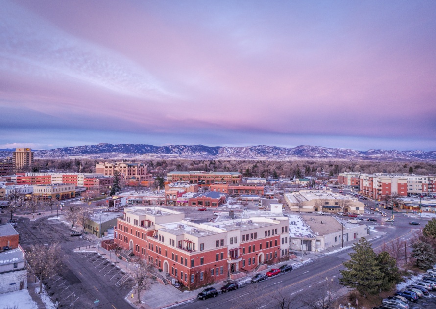 FORT COLLINS, CO, USA - DECEMBER 13, 2016: Downtown of Fort Collins, Colorado at cold winter dawn - aerial view with holiday lights and Rocky Mountains in background..