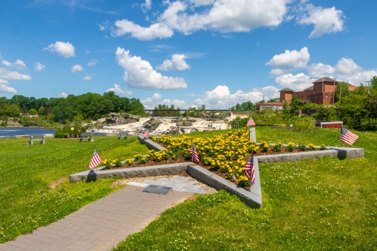 Lewiston, Maine / USA - June 22 2019: Gold Star Mothers memorial in Veterans Memorial Park with Lewiston Falls in the background