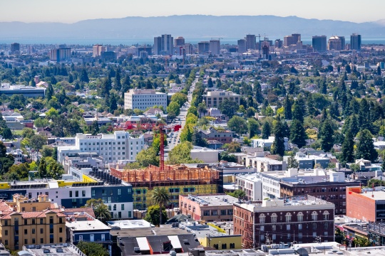 Aerial view of Berkeley and Northern Oakland on a sunny day; Downtown Oakland in the background; San Francisco Bay, California