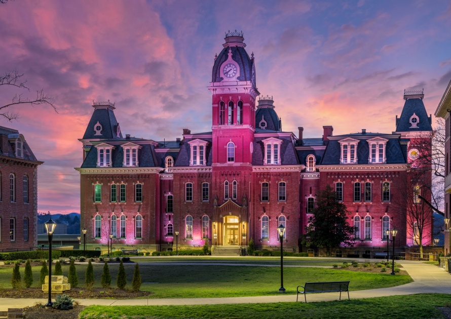 Morgantown, WV - 8 March: Dramatic image of Woodburn Hall at West Virginia University or WVU in Morgantown WV as the sun sets behind the illuminated historic building